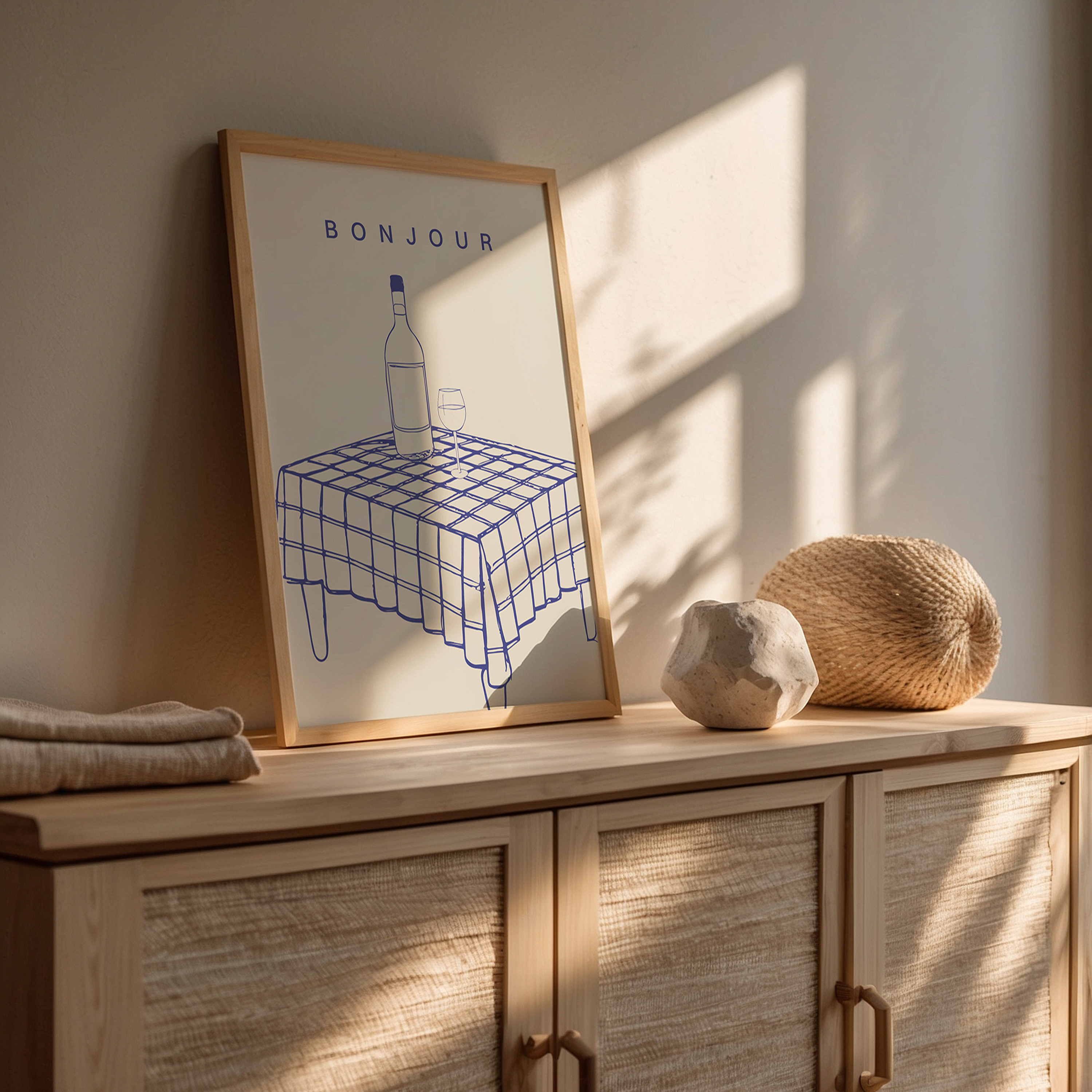 Grafische poster in beige met blauw, tafel met fles wijn en tekst ‘Bonjour’, Franse keukenwanddecoratie.